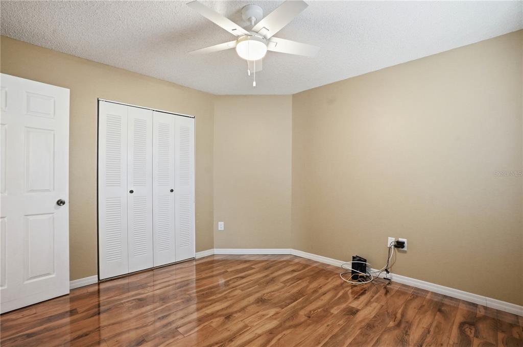 5277 Deltona Boulevard Spring Hill, FL 34606 - Photo 39 of 74 a view of a room with wooden floor and a ceiling fan