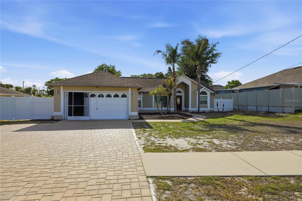 5277 Deltona Boulevard Spring Hill, FL 34606 - Photo 72 of 74 a front view of a house with a yard and garage
