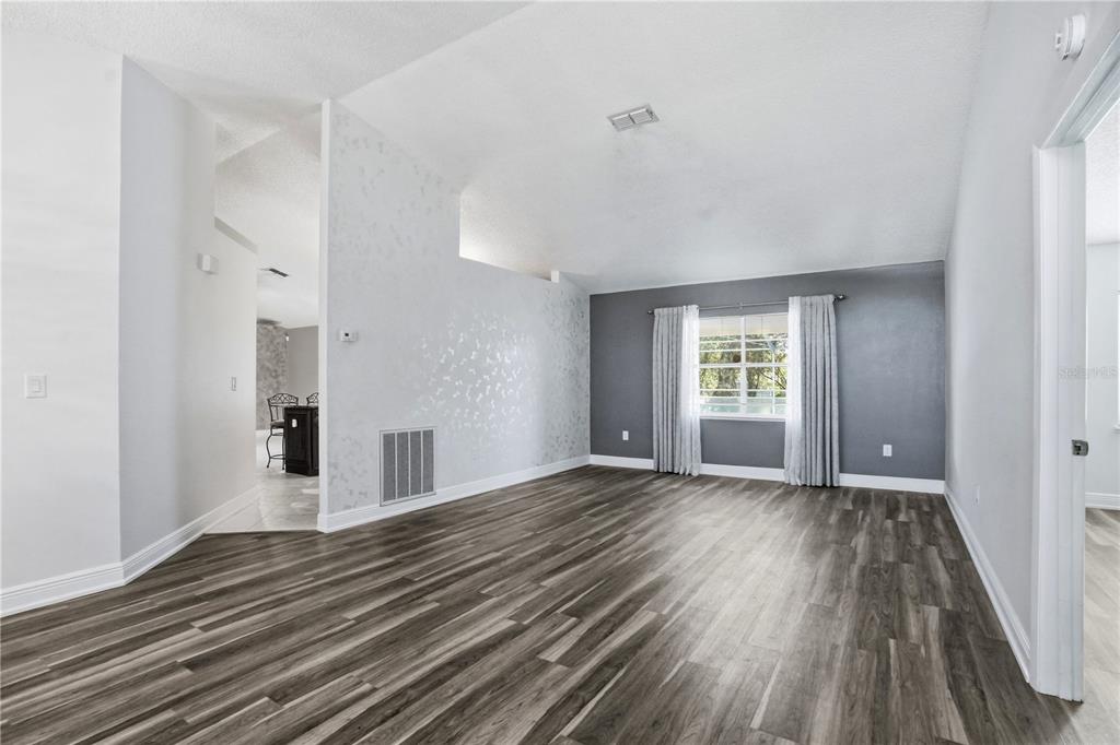 5277 Deltona Boulevard Spring Hill, FL 34606 - Photo 9 of 74 a view of a room with wooden floor and window