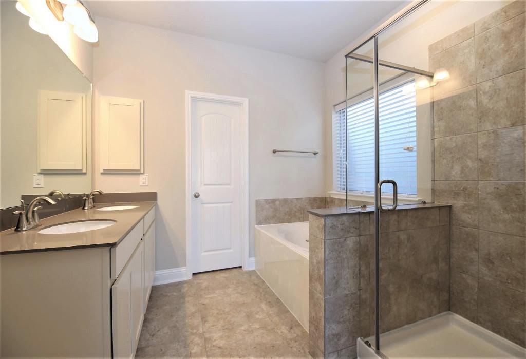 8202 Aleppo Pine Lane Cypress, TX 77433 - Photo 17 of 31 a bathroom with a granite countertop sink and a mirror