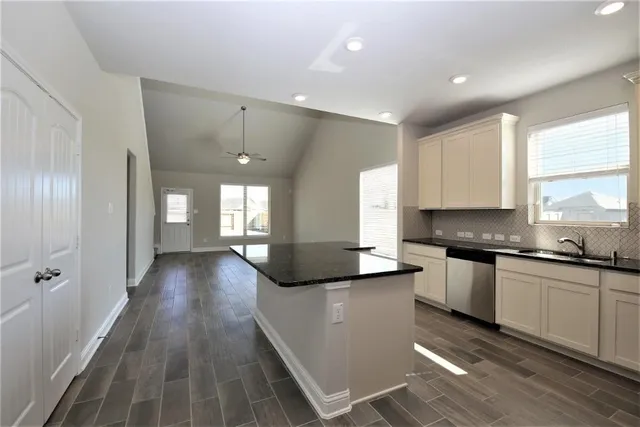 a large kitchen with granite countertop lots of counter top space and stainless steel appliances
