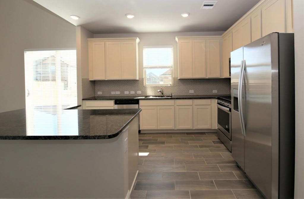 8202 Aleppo Pine Lane Cypress, TX 77433 - Photo 7 of 31 a kitchen with stainless steel appliances granite countertop a sink a stove a refrigerator and a microwave