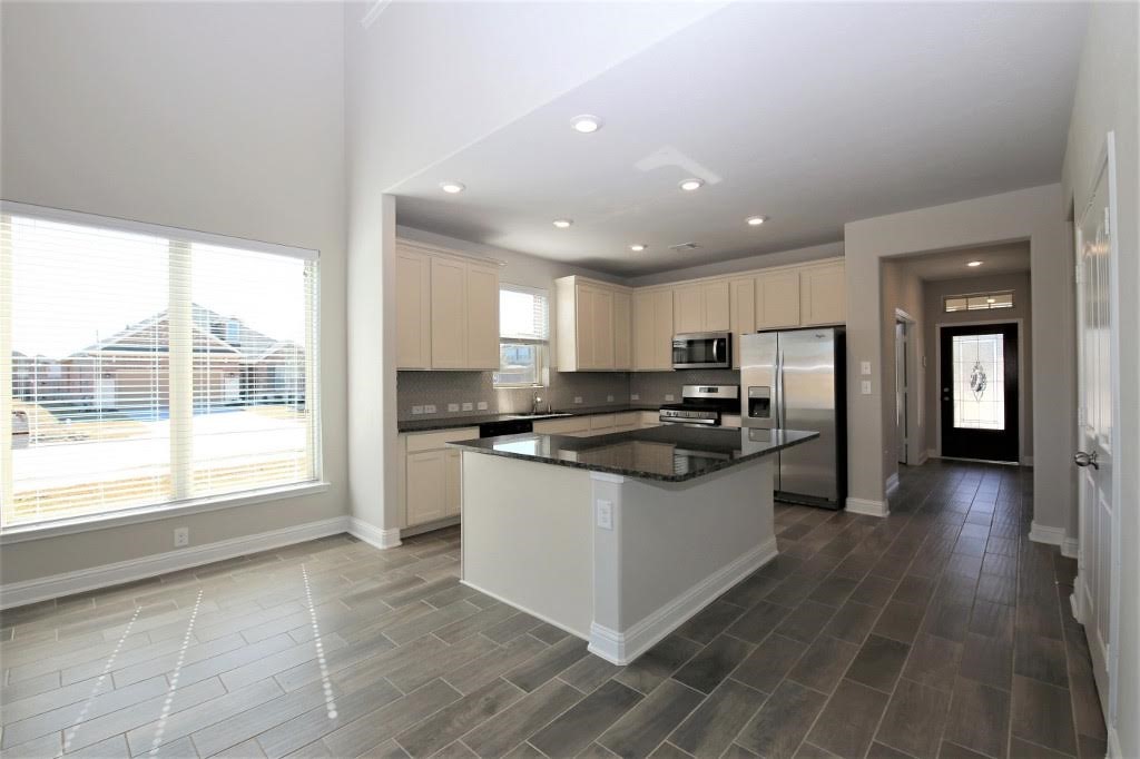 8202 Aleppo Pine Lane Cypress, TX 77433 - Photo 8 of 31 a kitchen with stainless steel appliances granite countertop a stove a sink and a refrigerator