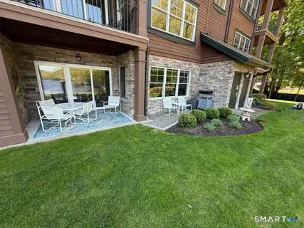 a view of a chair and table in backyard of the house