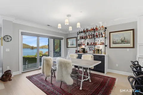 a view of a dining room with furniture a rug and wooden floor