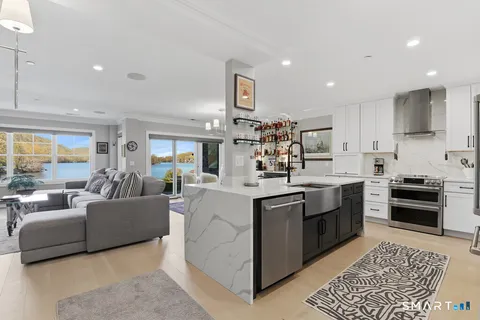 a open kitchen with stainless steel appliances granite countertop a stove and a sink