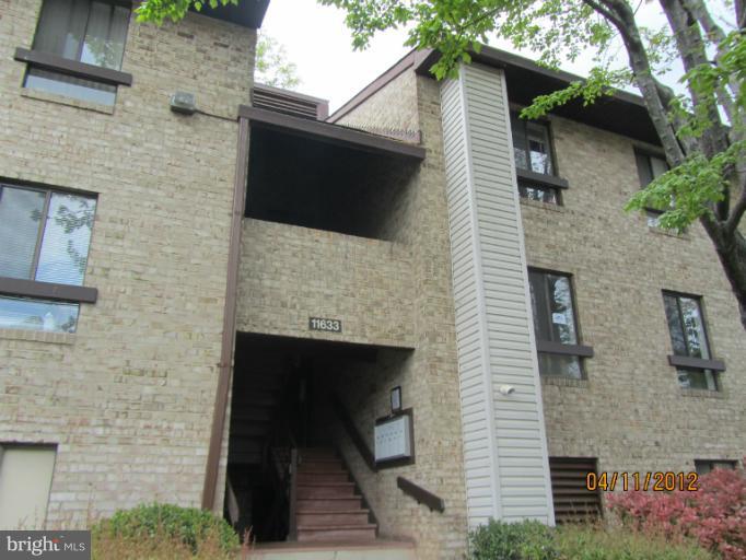 11633 Stoneview Square, Unit 81/12C Reston, VA 20191 - Photo 8 of 16 a brick house with a door and a large tree