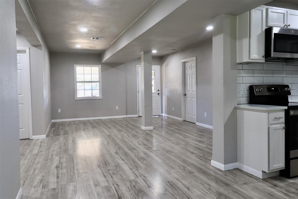 11400 Lakeview Circle Brenham, TX 77833 - Photo 6 of 9 a view of a kitchen and an empty room with wooden floor and a window