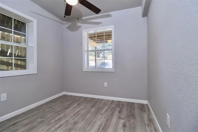 an empty room with a window and wooden floor