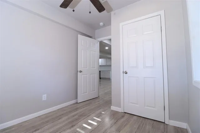 an empty room with wooden floor and closet
