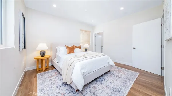 a bedroom with a bed and wooden floor