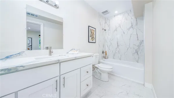 a bathroom with a double vanity sink toilet and shower