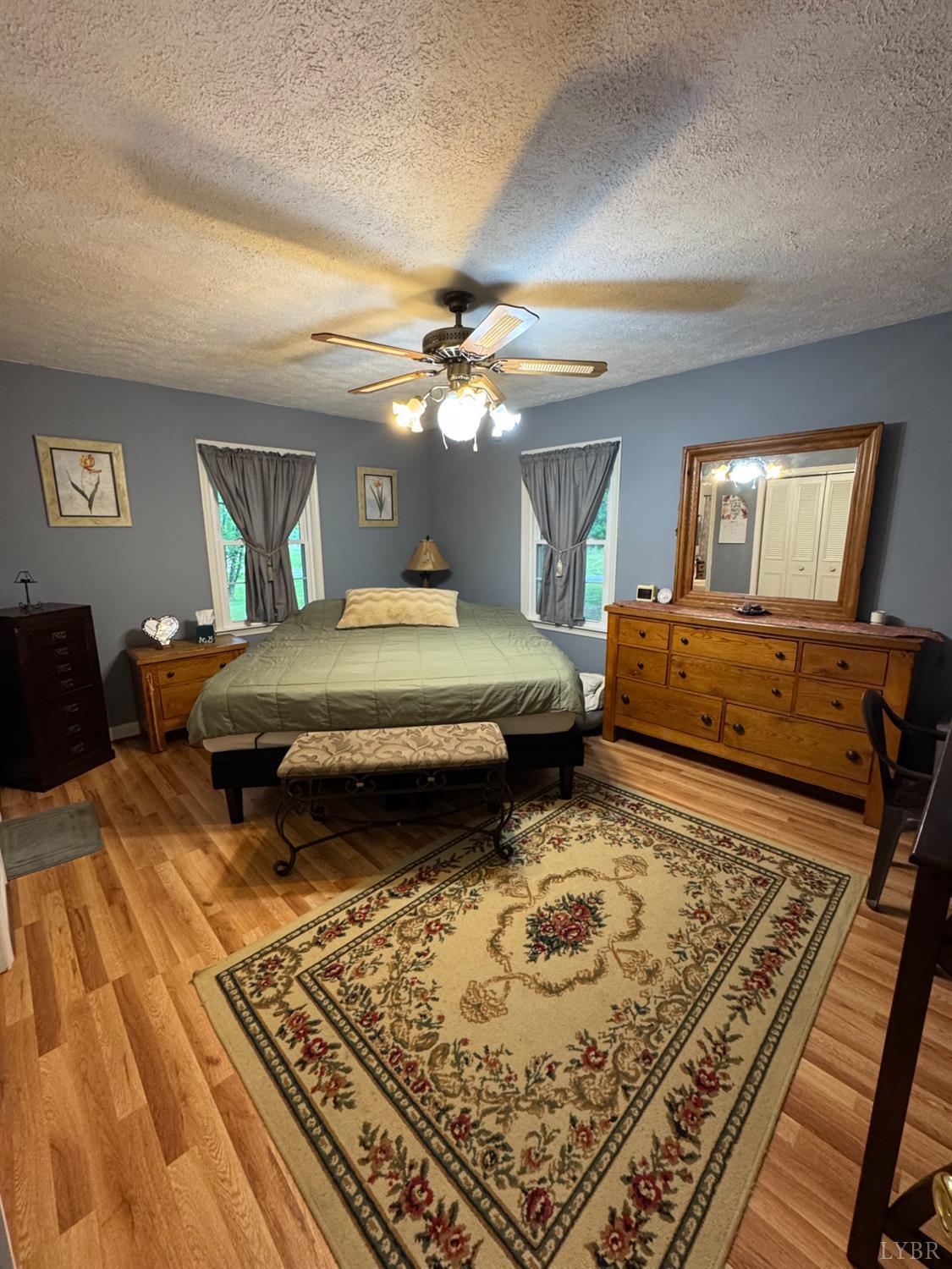 100 New Chapel Road Rustburg, VA 24588 - Photo 18 of 44 a bedroom with a bed a mirror on dresser and a chandelier