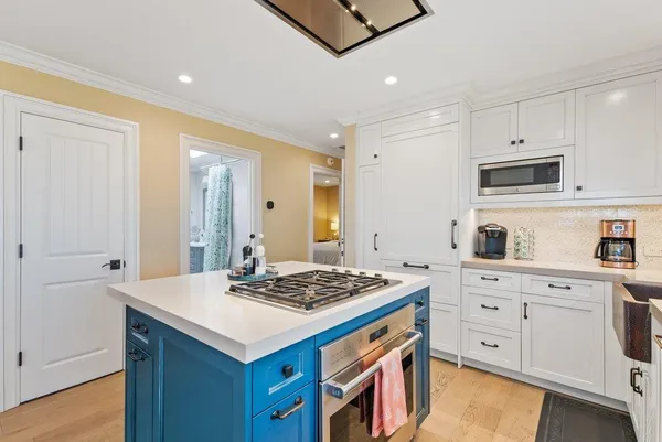 a kitchen that has a lot of cabinets in it and wooden floors