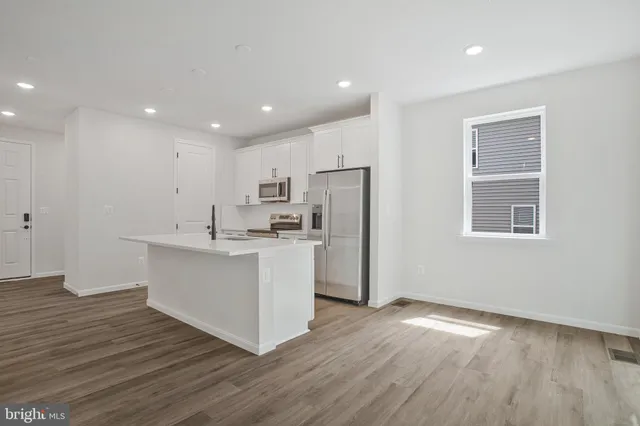 a kitchen with a refrigerator and white cabinets