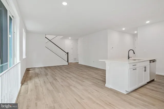 a view of a kitchen with sink wooden floor and staircase