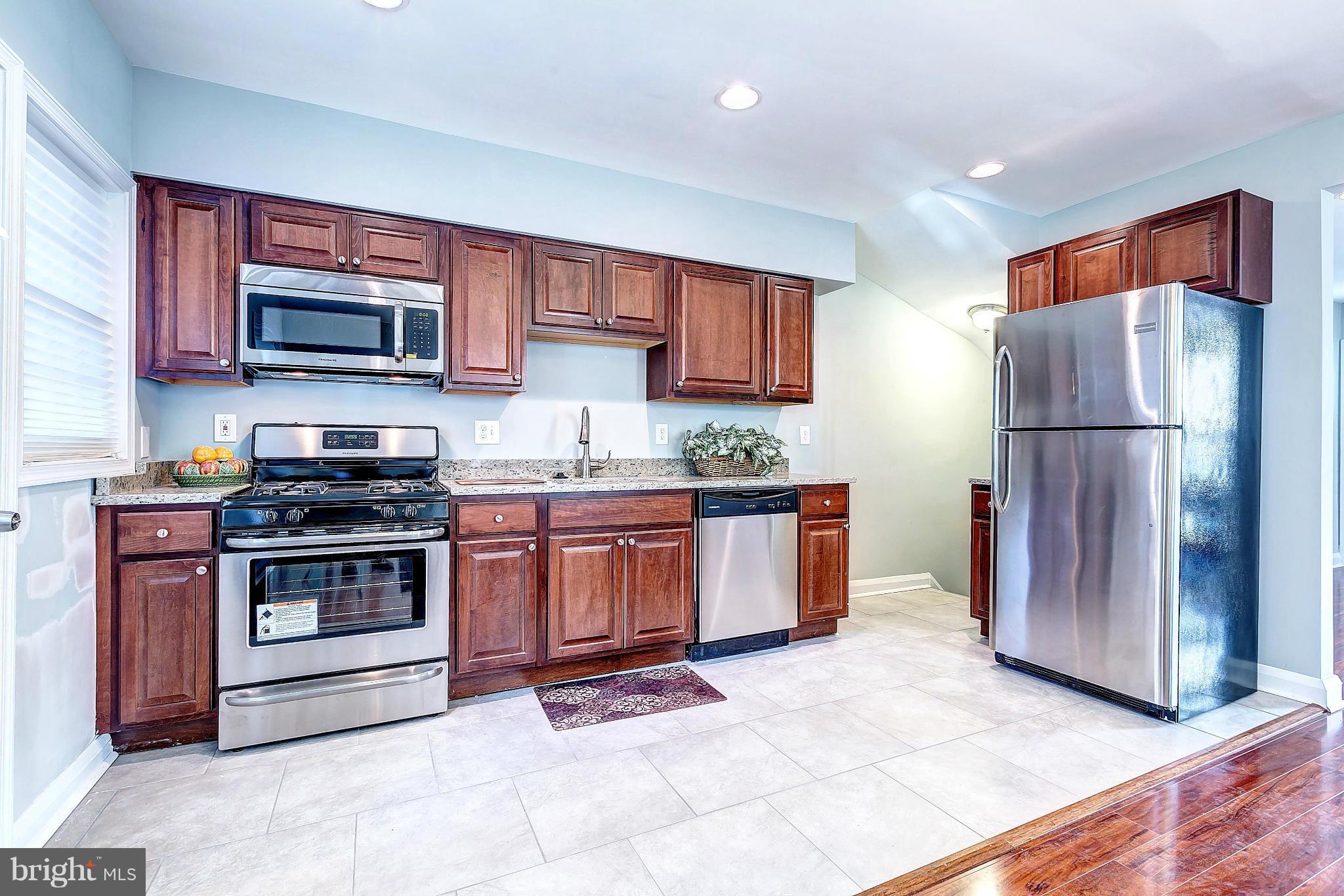 968 North Hill Road Baltimore, MD 21218 - Photo 12 of 29 a kitchen with granite countertop a refrigerator and a stove top oven
