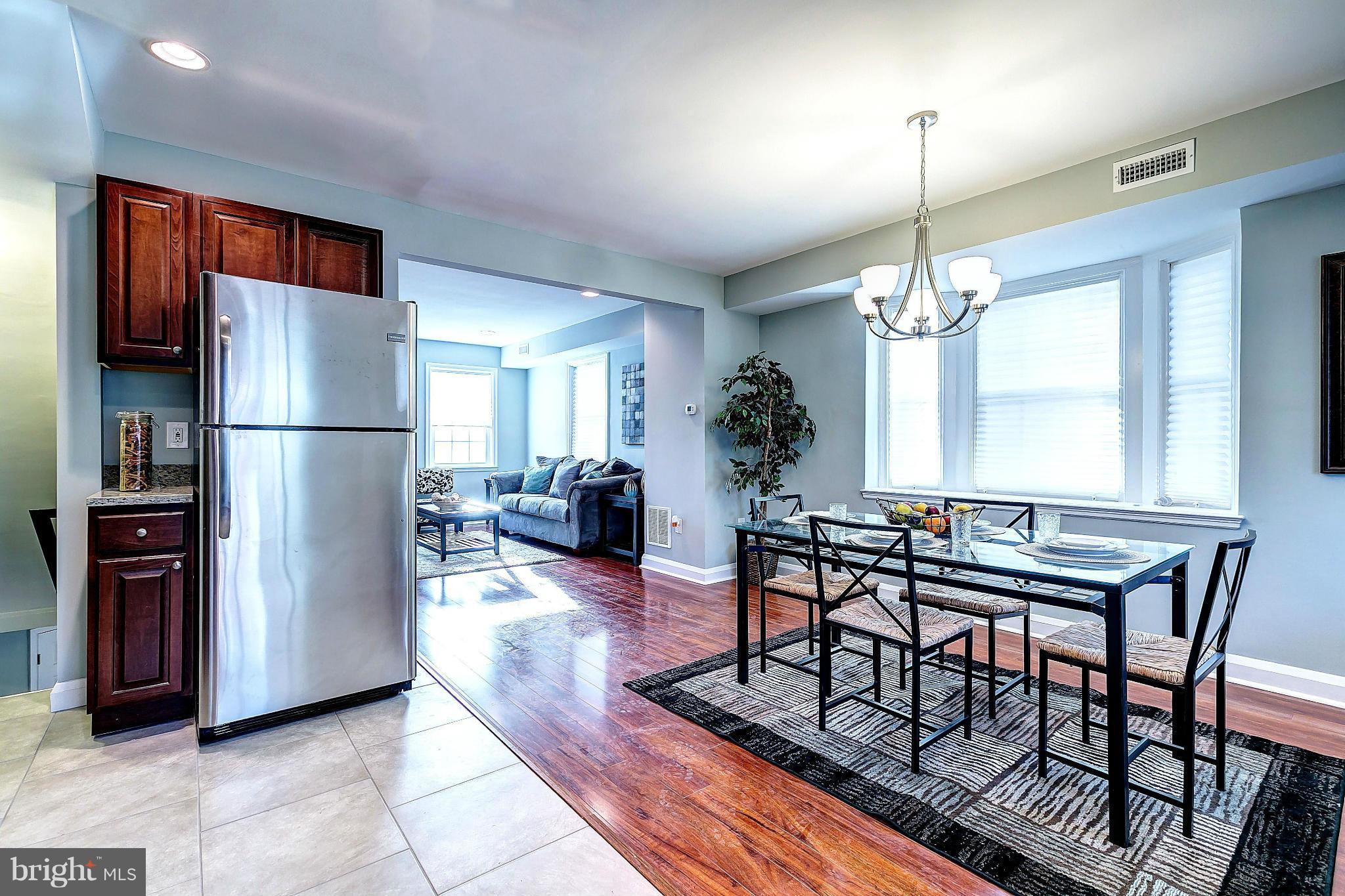 968 North Hill Road Baltimore, MD 21218 - Photo 13 of 29 a kitchen with a refrigerator a table and chairs