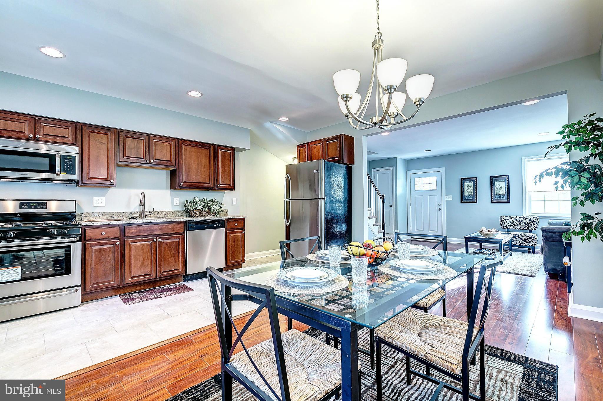 968 North Hill Road Baltimore, MD 21218 - Photo 4 of 29 a open kitchen with stainless steel appliances granite countertop a dining table chairs stove top oven and refrigerator