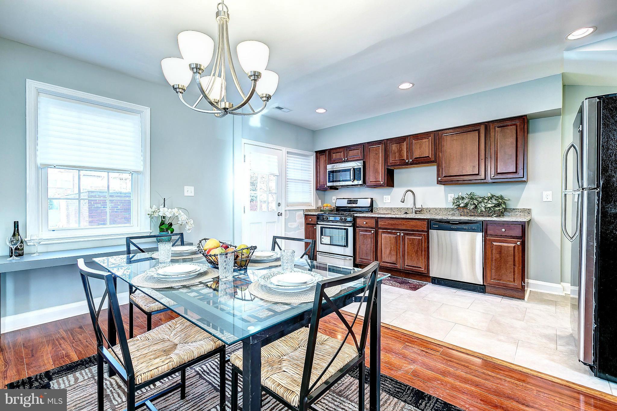 968 North Hill Road Baltimore, MD 21218 - Photo 8 of 29 a view of a dining room with furniture a kitchen and chandelier