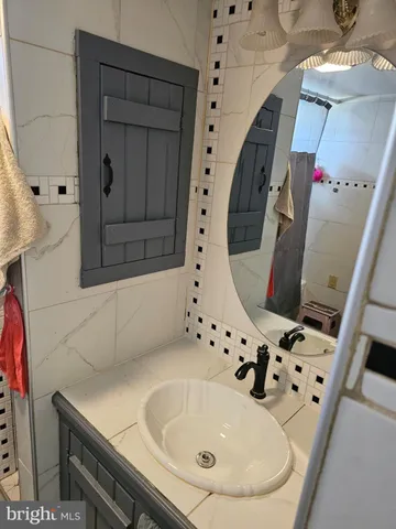 a bathroom with a sink and mirror with bathtub