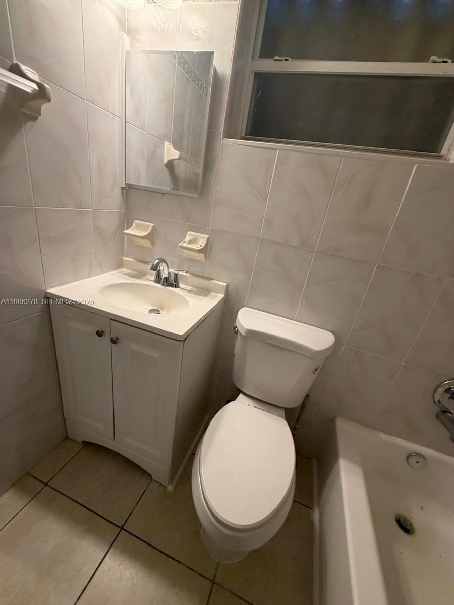 751 Northwest 96th Street, Unit 751 Miami, FL 33150 - Photo 6 of 11 a bathroom with a toilet sink and mirror
