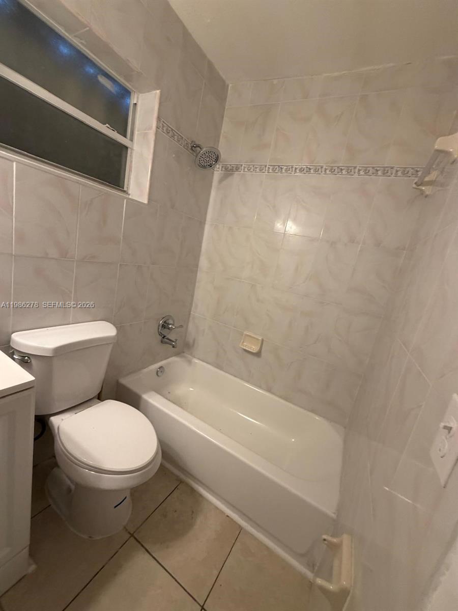 751 Northwest 96th Street, Unit 751 Miami, FL 33150 - Photo 7 of 11 a white toilet sitting next to a bath tub and a shower