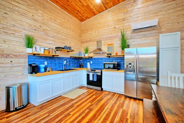 a kitchen view with wooden floor and stainless steel appliances