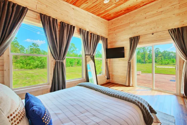 a bedroom with a bed and a large window with outer view