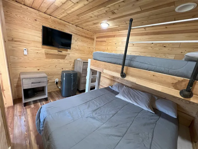 a bedroom with a bed and a flat screen tv