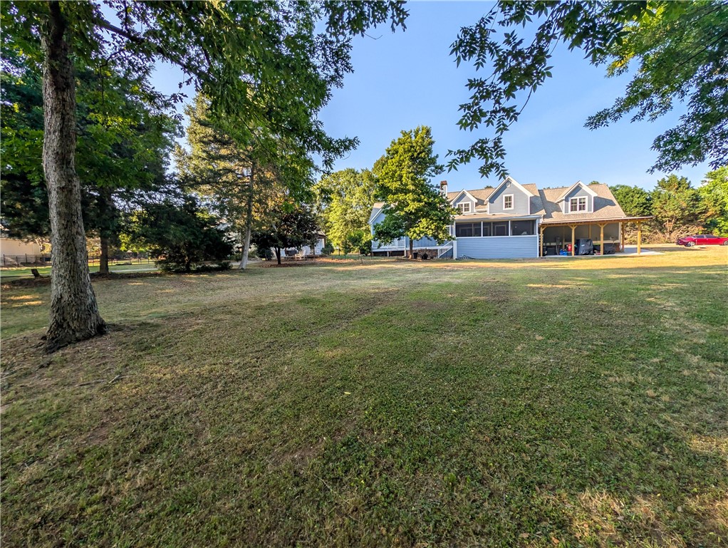 1504 Double Springs Road Townville, SC 29689 - Photo 40 of 41 Vast green lawn extends towards a welcoming residence with a screened porch.