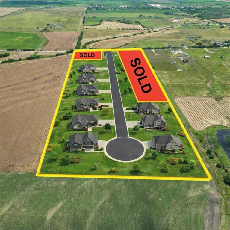 a sign that is sitting in the grass next to a yard