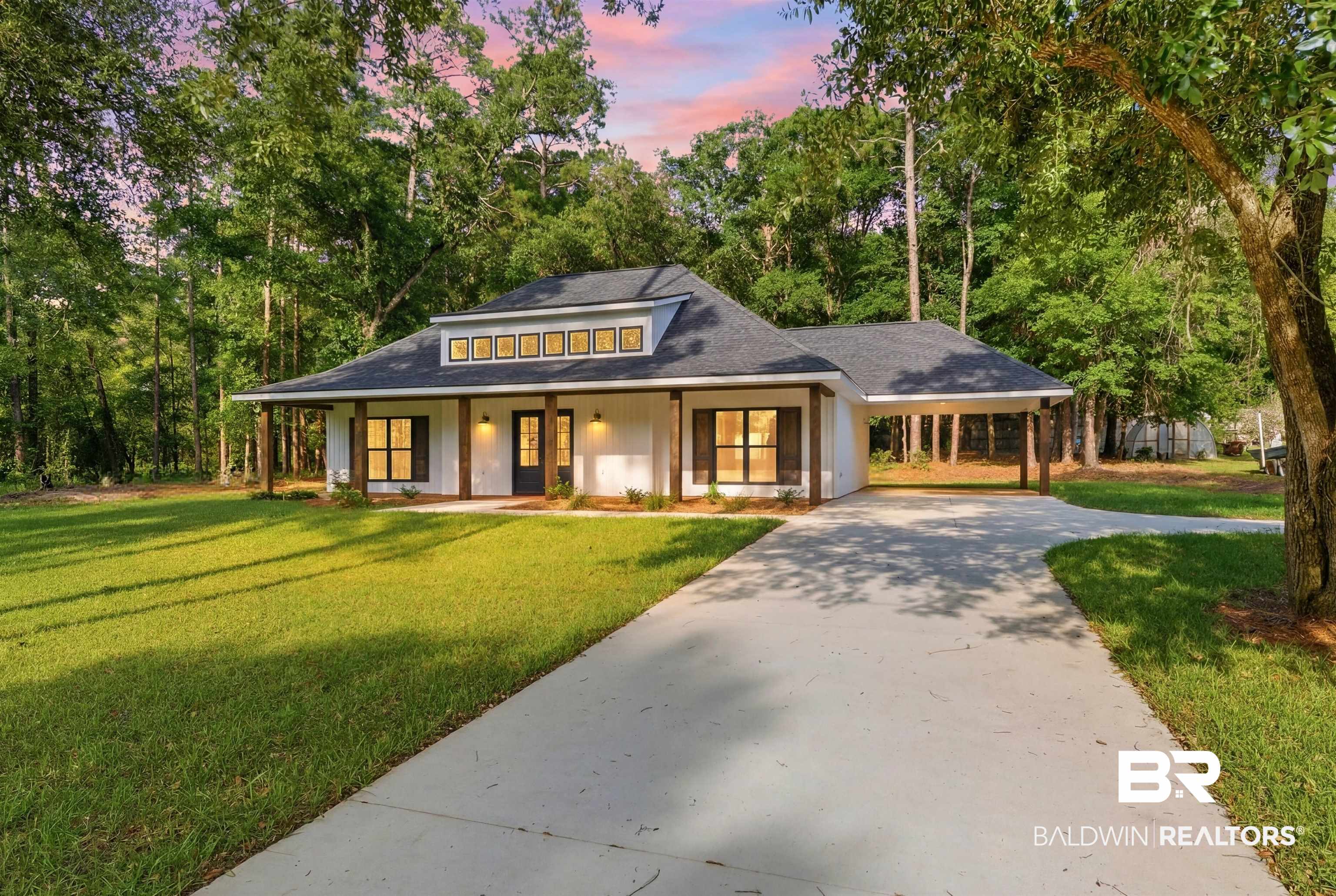 14128 Jackson Lane Foley, AL 36535 - Photo 2 of 36 Contemporary farmhouse exterior featuring white siding, dark trim, a dark asphalt shingle roof, wood support columns, and a dormer with multiple windows