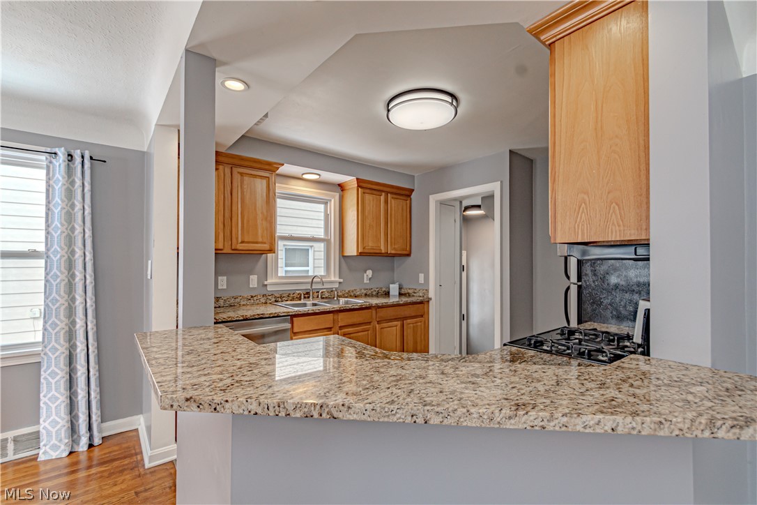 4157 Verona Road Cleveland, OH 44121 - Photo 5 of 26 Kitchen featuring recessed lighting, light stone countertops, light wood-type flooring, dishwasher, and a peninsula