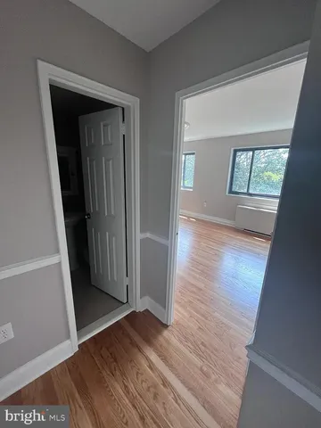 an empty room with wooden floor and a window