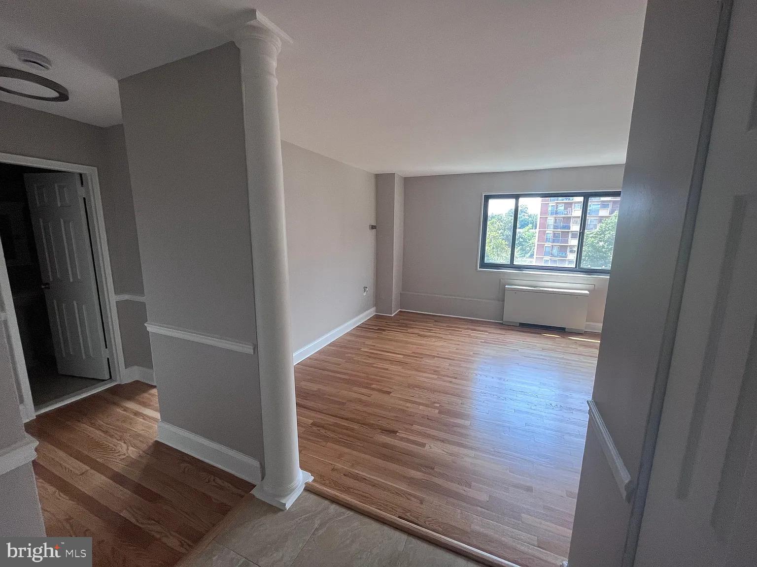 1200 South Arlington Road, Unit 504 Arlington, VA 22209 - Photo 8 of 20 an empty room with wooden floor and windows