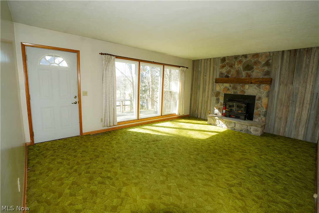 6198 Arrow Road Northwest Minerva, OH 44657 - Photo 2 of 17 Unfurnished living room with a stone fireplace and carpet flooring