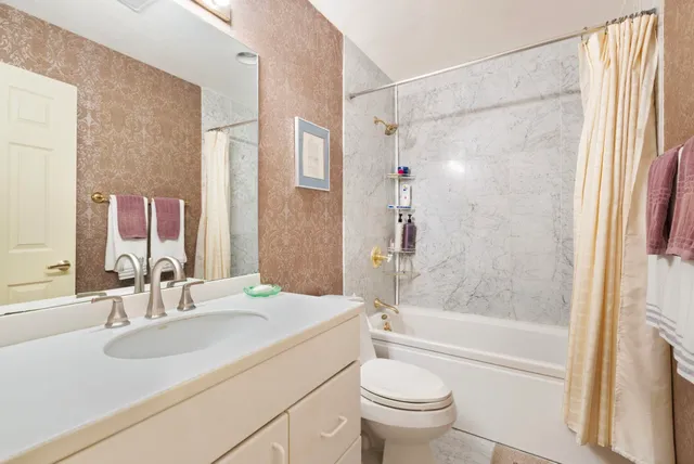a bathroom with a granite countertop sink toilet and shower