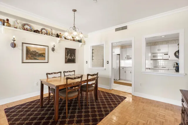 a dining room with wooden floor and a chandelier