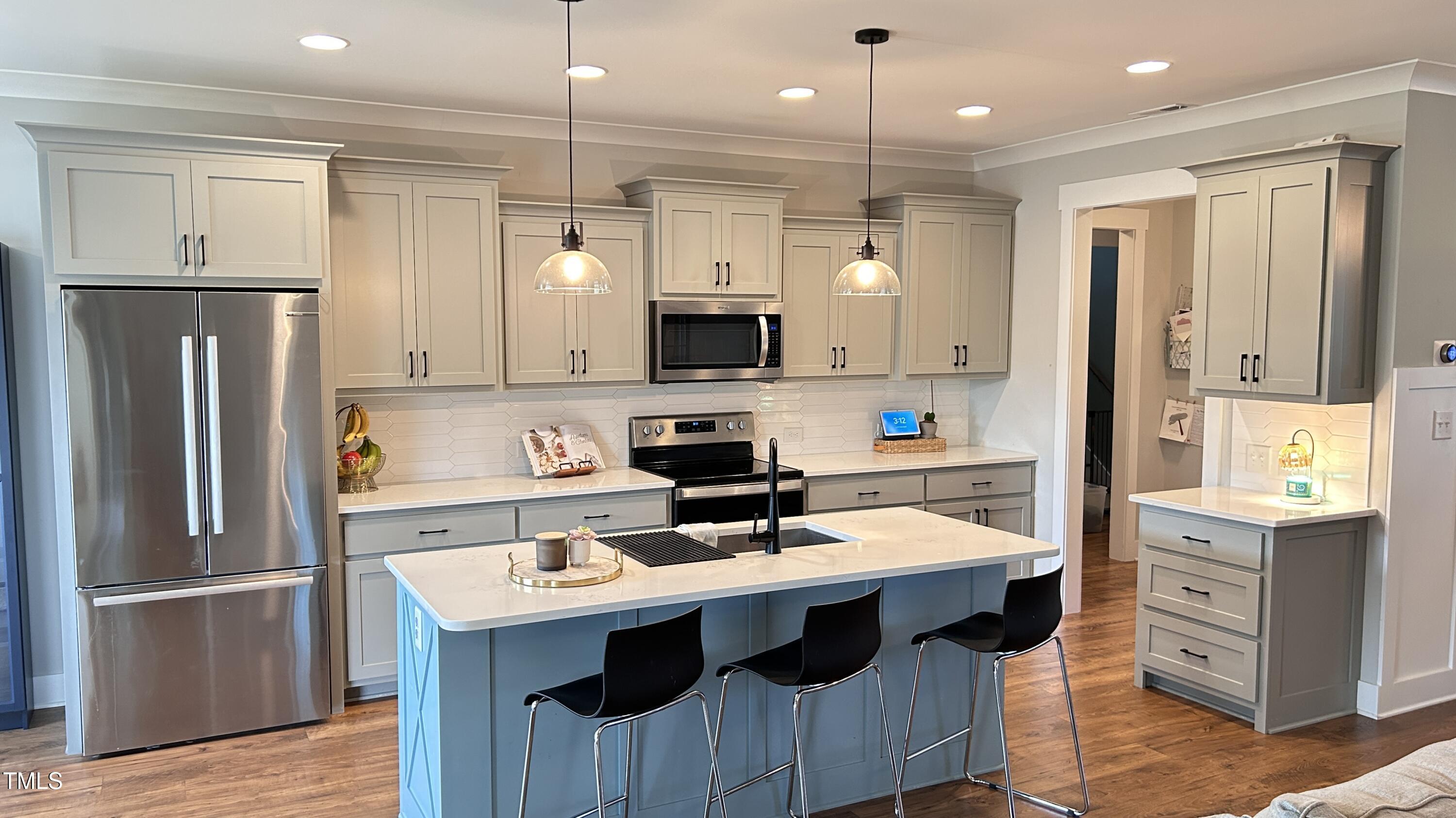 18 Pawnee Place Willow Spring, NC 27592 - Photo 11 of 35 a kitchen with a refrigerator a sink and a stove top oven with wooden floor