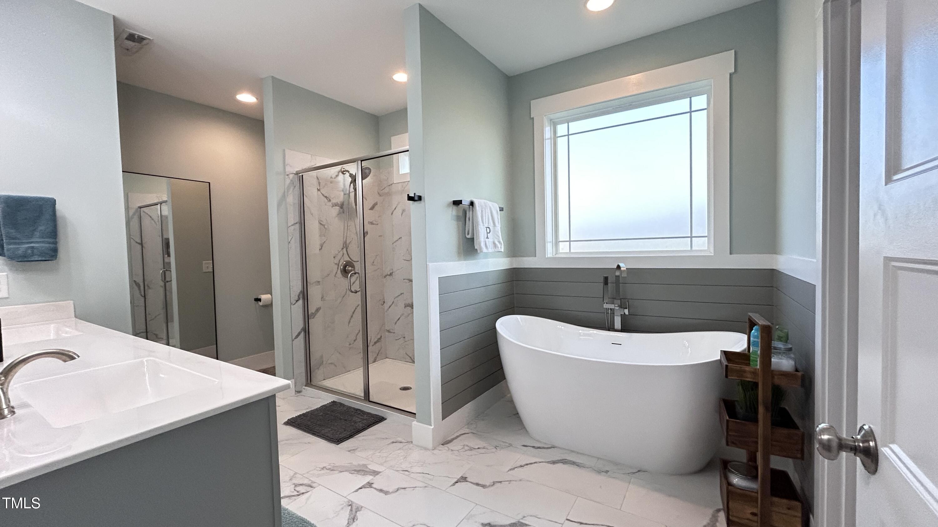 18 Pawnee Place Willow Spring, NC 27592 - Photo 21 of 35 a bathroom with a white tub sink shower and a mirror