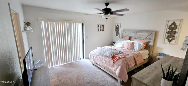 a bedroom with bed and a large window