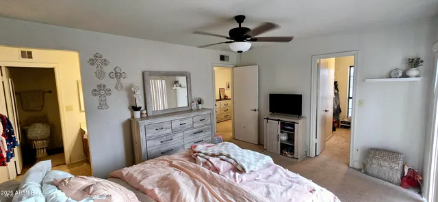 a bedroom with a bed and a flat tv screen on dresser