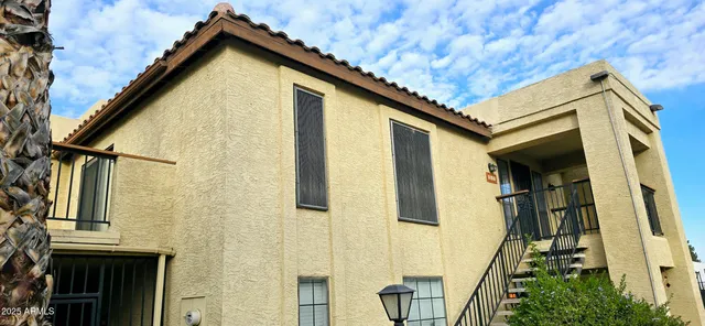 a view of a house with a wooden door and deck