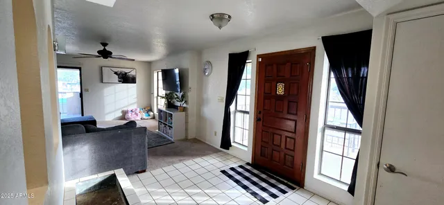 a hallway with wooden floor windows and a livingroom