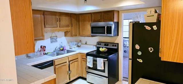 a kitchen with stainless steel appliances granite countertop a refrigerator and a stove