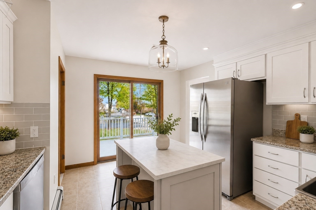 67 Wituwamat Road Weymouth, MA 02191 - Photo 11 of 42 a kitchen with stainless steel appliances granite countertop a refrigerator and a stove top oven