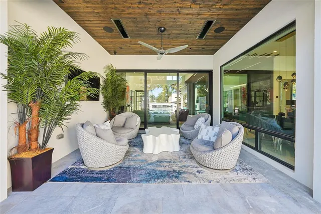 a living room with patio furniture and a potted plant