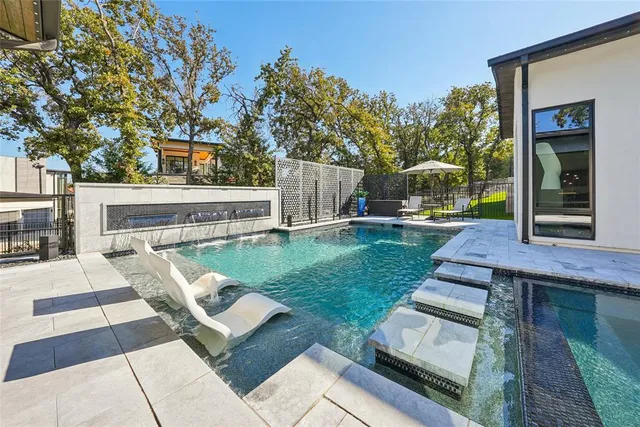 a view of a patio with couches table and chairs with wooden floor and fence