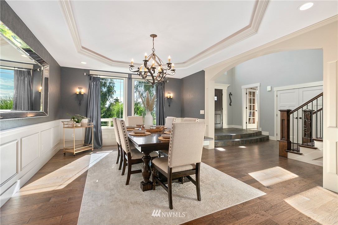 5745 Barr Road Ferndale, WA 98248 - Photo 6 of 40 a dining room with wooden floor a chandelier a wooden table and chairs